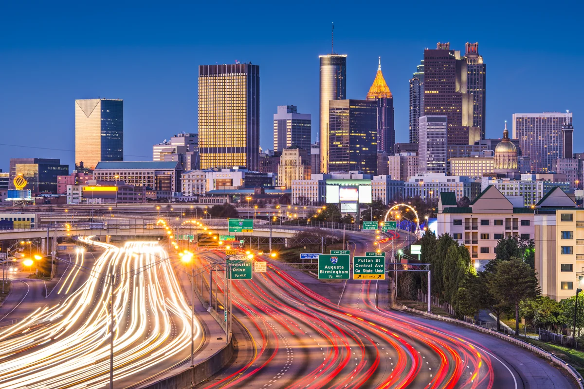 Downtown Atlanta skyline at dusk over light trails on the Connector